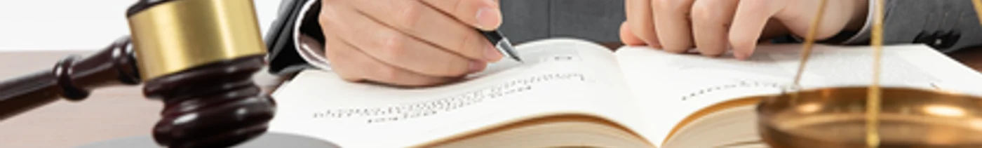 ed244550-cea4-4b0d-bffa-4aae6d3cb184-closeup-shot-person-writing-book-with-gavel-table(1).png